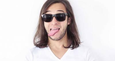 Long-haired man sticking his tongue out