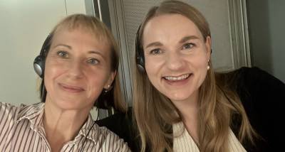 Two interpreters in the booth: the image shows an image of two smiling women wearing headsets.